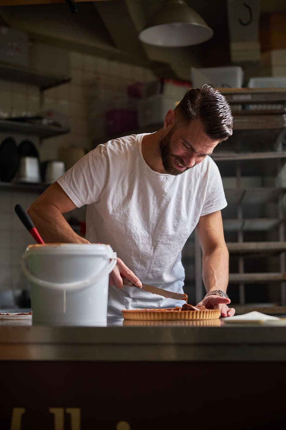 Daniel Mellicovsky finishing a fresh stroopwafel tart in the kitchen